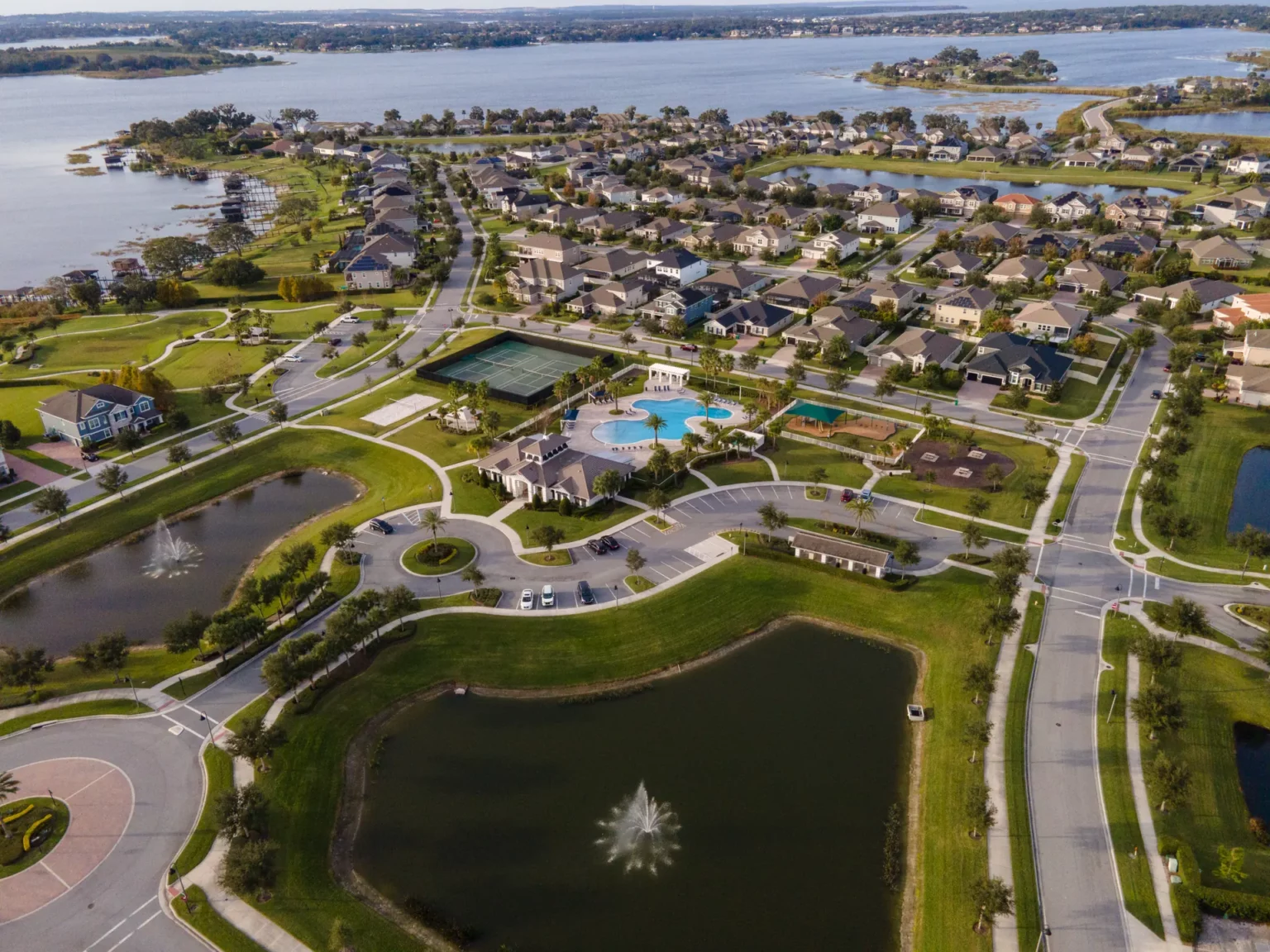 Aerial view of a fountain pond and homes in Hickory Hammock at Johns Lake